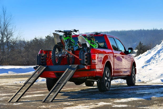 The new 2015 Ford F-150 features some thoughtful accessory options to buyers dont have to immediately turn to the aftermarket, such as these loading ramps for loading dirt bikes and ATVs into the truck bed.