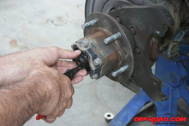 Using snap-ring pliers, remove the axles snap-ring retainer.