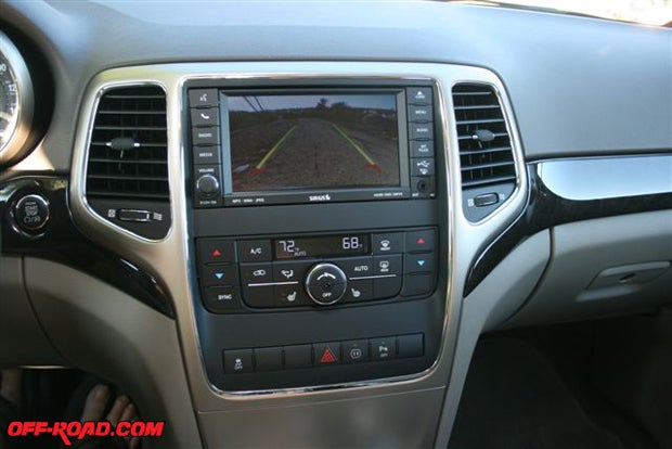 Those two yellow lines you see in the backup screen show the driver the outside path of the vehicle. Put the gearshift in reverse and the rear view automatically replaces the touch screen audio system controls. The Grand Cherokee also has an object sensing system that operates when in reverse. Youll also notice dual controls for the front A/C and heater systems.