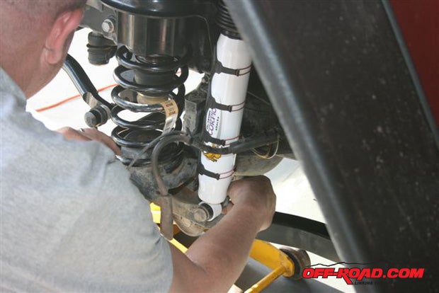 Install the new shocks and sway bar links using the factory hardware. Re-insert the ABS lines into their brackets, and install the front wheels and drop the Jeeps front end.