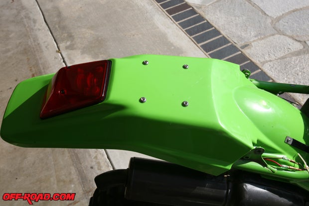 Although we unfortunately cannot make our two-stroke-powered KDX 200 street legal in California, we went ahead and installed the rear taillight. Although Kawasaki no longer offer the tool kit for the rear fender, we purchased some stainless-steel bolts to plug the holes and give it a cleaner look.