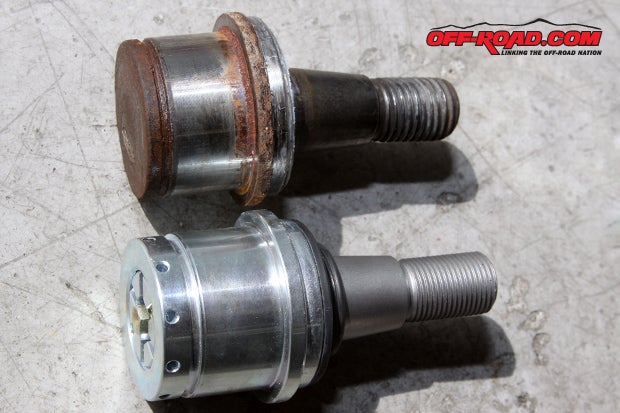Side-by-side comparison of the stock lower OE ball joint (top) and lower Dynatrac Pro Steer Ball Joint (bottom). Notice the needle grease fitting on top.