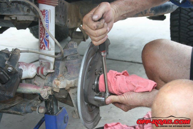 Protect the axle sleeve and remove the disc brakes backing plate.