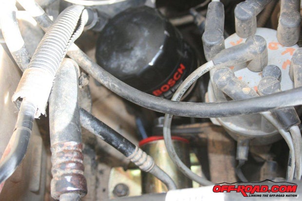 With the new motor mount in place, reattach the Cherokees oil filter. Dont forget to reconnect the battery.