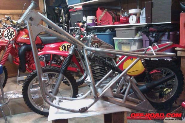 Complete bare chassis with shocks; conventional Maico in background.