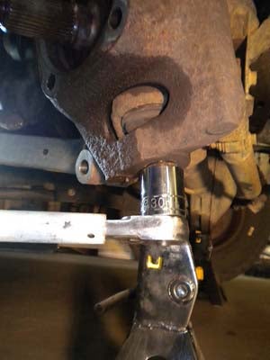 Use a 30mm socket to loosen the nut on the lower ball joint.