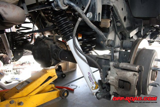 Install the new longer Daystar shocks. Bolt them into place starting at the top and then doing the lower bolts. Reconnect all components, install the rear tires, and drop the Jeep to the ground.