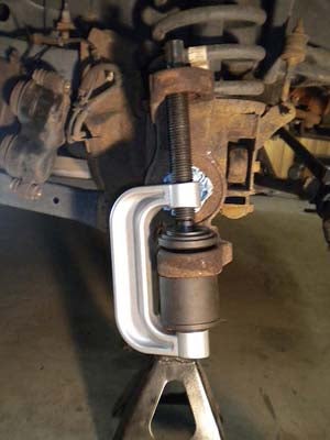 Pressing out the lower ball joint - notice how the screw on the ball joint press runs through the upper ball joint hole? That’s why you need to press the upper one out first. The lower ball joint gets pressed out through the bottom. 