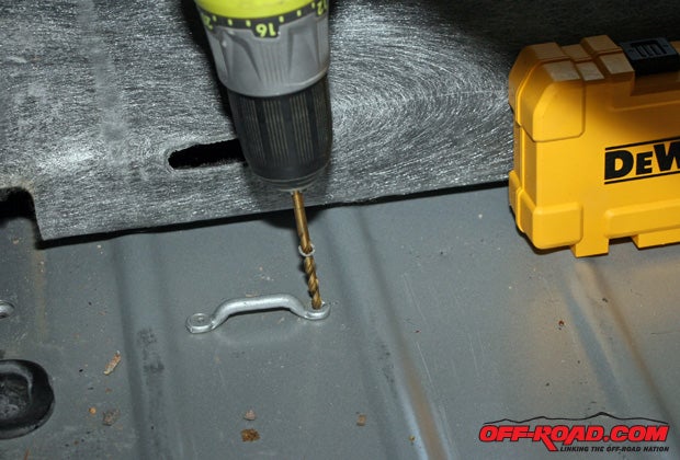 There were several factory attachment points on the Jeeps floorboards. We drilled out the pop rivets and saved the brackets for use later on.