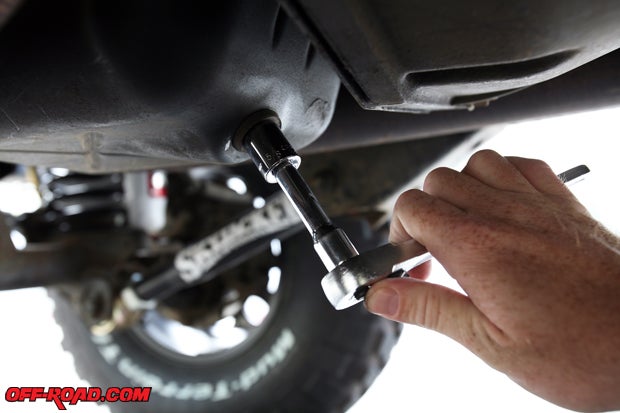 Using a 5/8 socket or wrench, loosen the oil drain plug to remove the engine oil. Once loosened, you should be able to finishing unscrewing it with your fingers.