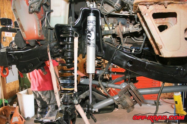 Support both ends of the axle housing and install the shock absorbers. If you’re going to install limiting straps, now is the time. You want them so that when the axle housing extends downward, the strap will stop it from hanging on the shock. About an inch shorter than the shock’s maximum length will work.