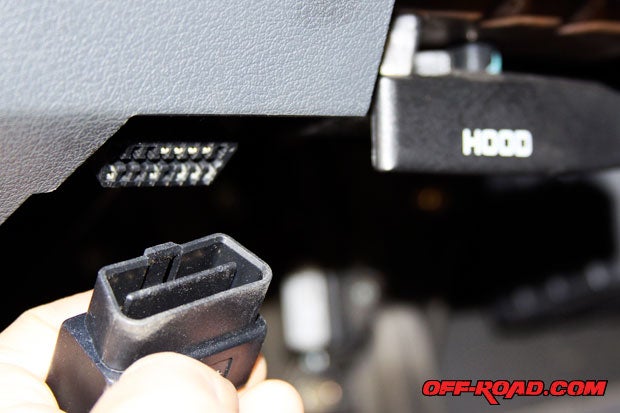 Locate the OBD-II port inside the cab. On our 3rd Gen. Dodge Ram it is located in the drivers side lower left corner of the dashboard, next to the hood latch. Plug in the Superchips Flashpaq with the OBD-II cable to start power programming.