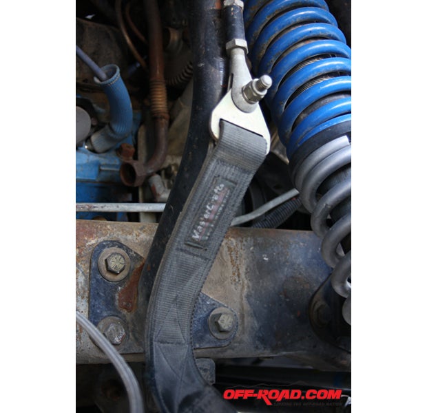 At their simplest in this two-beam Ford application (using an adjustable clevis mounted to a piece of tubing welded to a shock hoop mount), this strap limits vertical movement.