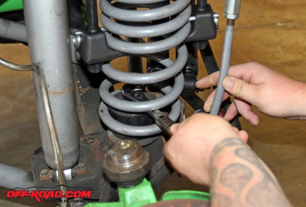 We loosen the lower bump stop prior to removing the spring.