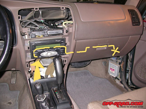 The Toyota antenna cable runs roughly from the arrow to the X, concealed behind the dash and stereo. Removing it requires patience.