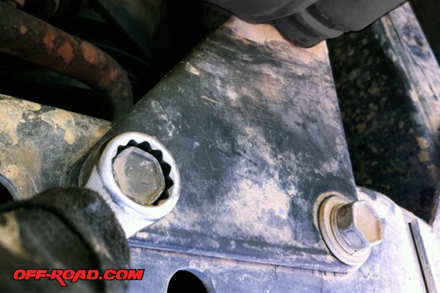 The second side of the steering damper is attached to a bracket on the frame. Remove bolts and bracket to be able and separate this end of the steering stabilizer from vehicle. The steering stabilizer can be removed from the bracket once off the vehicle using the tie-rod puller.
