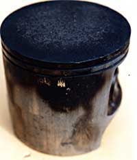 This piston shows the most common problem, blow-by. The rings were worn past the maximum ring end gap spec, allowing combustion pressure to seep past the rings and down the piston skirt causing a distinct carbon pattern. If the cylinder walls are glazed or worn too far, even new rings won't seal properly to prevent a blow-by problem.