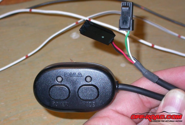 The PIAA two-range switch came with its own wire jacket, so we poked the plug end through the wiring port taped to a chaser wire.