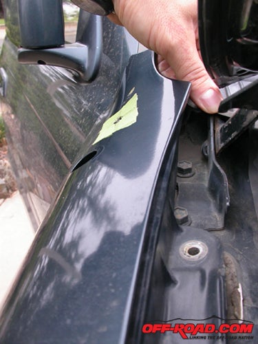 Remove a few bolts along the upper lip of the fender and you can pull it back, making it much easier to work on both sides of the fender. Note the masked hole.