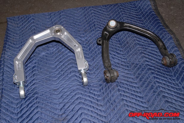 The difference between the CNC-machined Icon billet A-arm (left) and the stock Raptor A-arm (right) is readily apparent. The Icon A-arm also uses a Uniball pin rather than a ball joint. In addition to being stronger and able to accept longer shocks for more travel while retaining the stock A-arm length, the Uniball and heim joint on the Icon A-arm also make front end alignment easier.