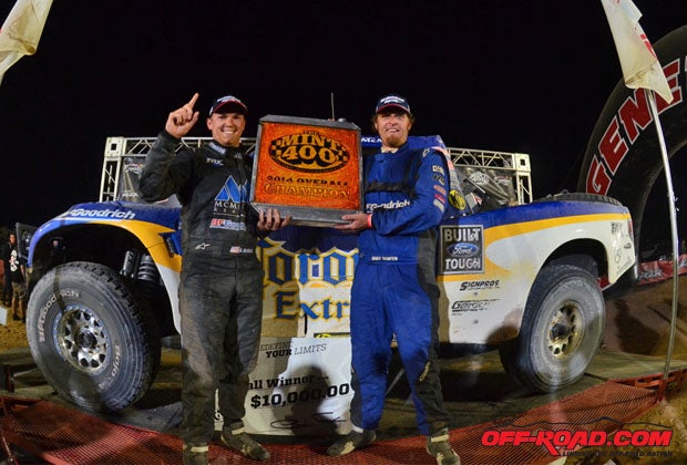 Andy McMillin and co-driver Brady Thompson hoist the trick Mint 400 radiator trophy at the finish line. 