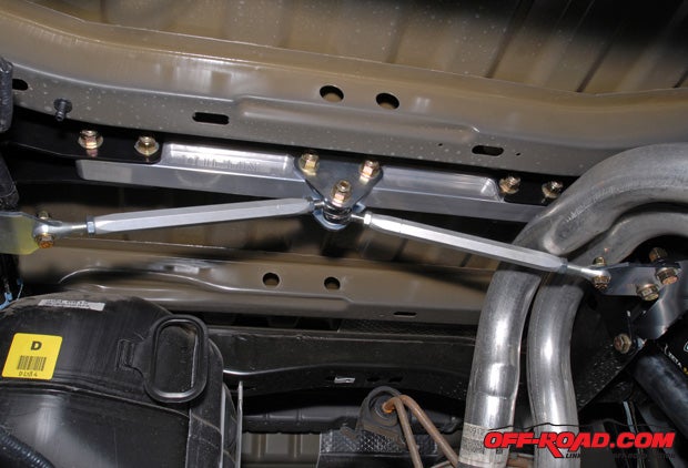 Here is an inside-the-frame look at the installed cross bar support. Note the minimal clearance between the right tension rod and the Raptors muffler. Poe corrected this by loosening up the exhaust system clamp forward of the resonator to slide the entire system back, gaining a little more room.