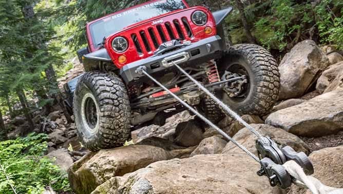 Jeep using winch with snatch block to pull up rocks