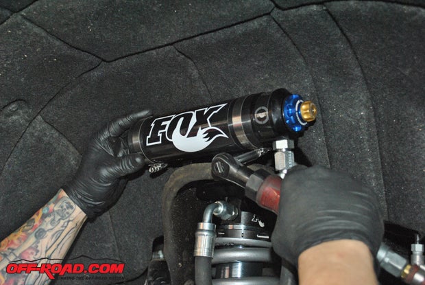 The Fox coilover's reservoir is secured in place, with the DSC adjustment screws easily accessible for tuning.
