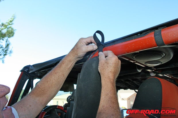 Wrap the center strap around the roll bar on both sides. Tighten the straps.
