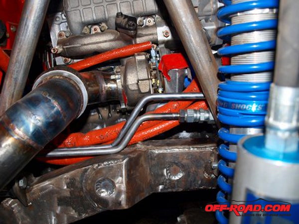 Oil cooler and power steering lines are wrapped in protective orange fire sleeves.