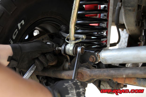 Once the vehicle is secure, we started to remove the stock components. To install the steering stabilizer mounting bracket in the kit we needed to remove the sway-bar disconnect on the passenger side from our 4-inch Skyjacker lift that was previously installed.