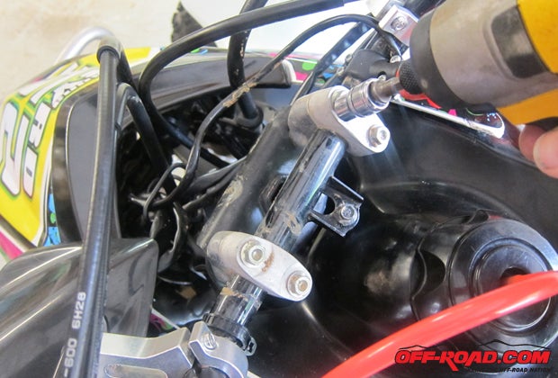 Use a socket to loosen the four bolts and separate the bars from the steering stem. 
