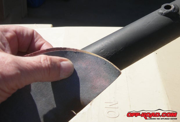 Medium-grit sandpaper was used to remove some of the globs of flat black paint that the previous owner had liberally applied to the frame.