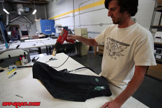 Stomp Designs Dave Molinari uses a heat gun to loosen the new seat cover before installation. 
