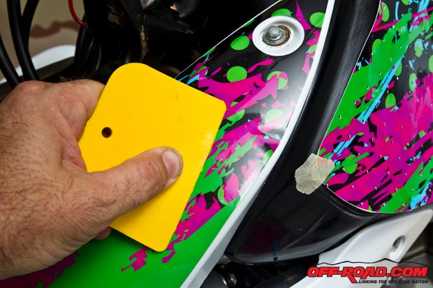 Move slowly using your thumbs or a squeegee across the decal and push out any pockets of air bubbles. Be sure to understand that the surface of the decal CAN be scratched, so gently squeegee the areas where this process is needed or you will be hating yourself later.