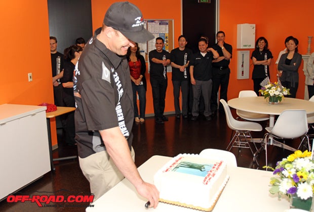 Loren Healy slices up his celebratory cake at Nitto Tire headquarters. 