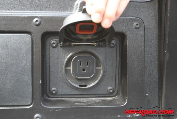 The Toyota Tacoma features a 115V AC outlet mounted to the rear passenger side of the truck bed. The opposite side of the truck bed features a small compartment to store tools and other gear. 